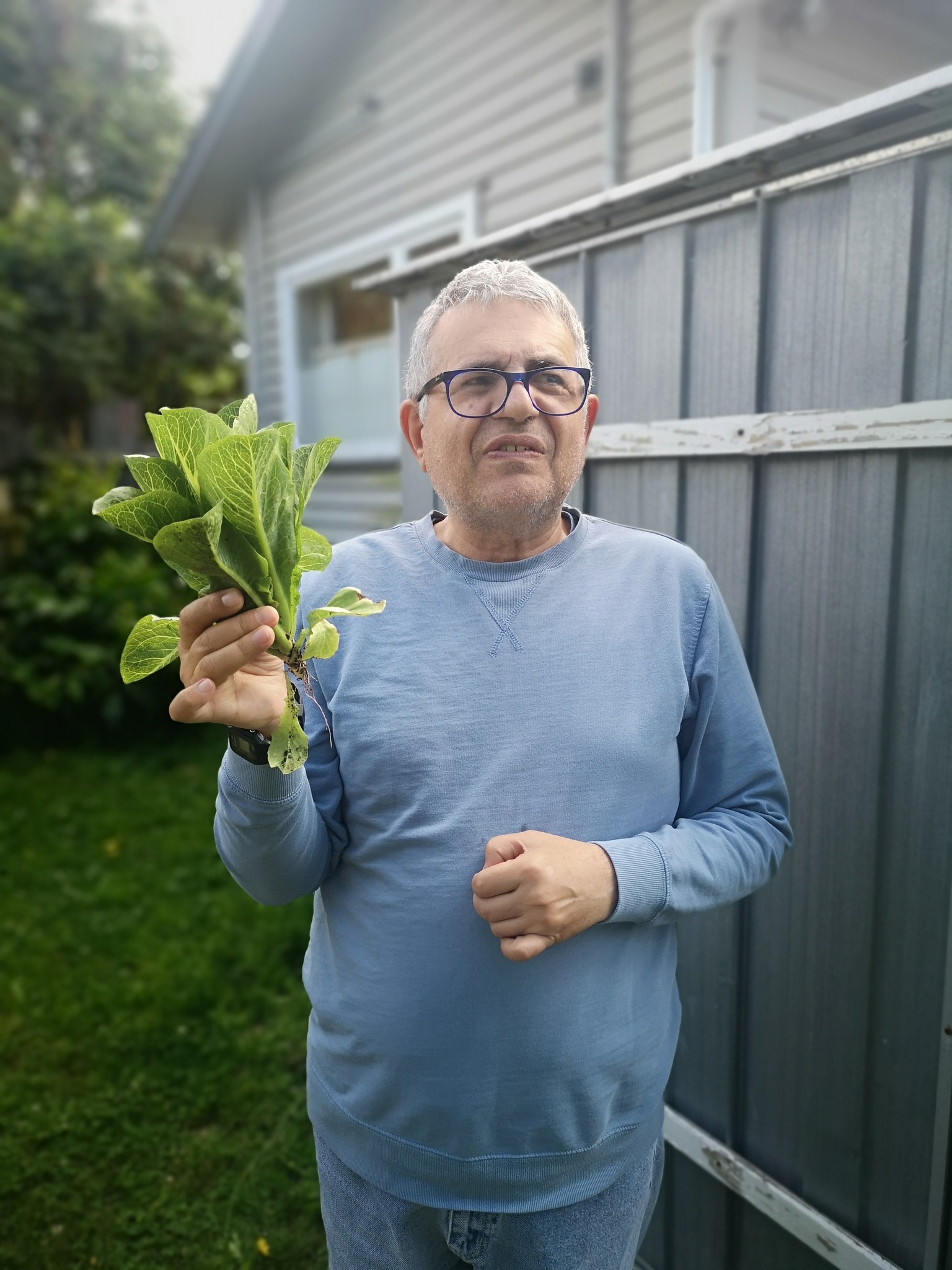 rpt Nik holding up fresh lettuce from his garden