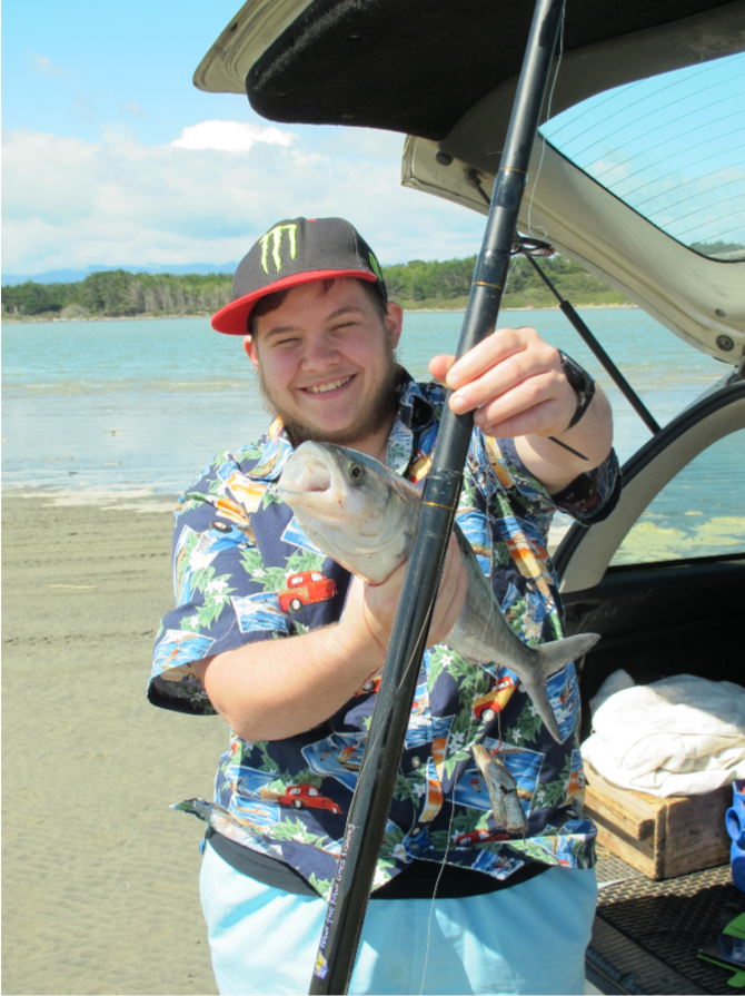 Ricky plus fish Rocky holding up a fish he caught with a big smile